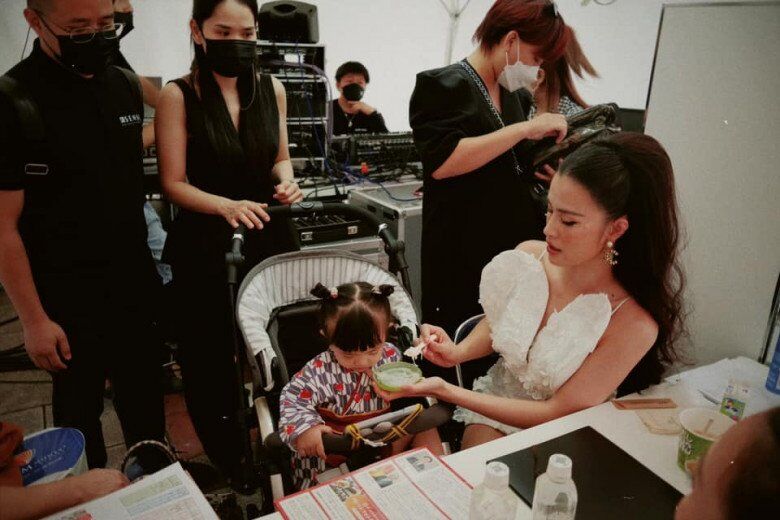 Sắp đến giờ lên sân khấu, Đông Nhi vẫn phải hoàn thành nhiệm vụ, vừa làm tóc vừa xúc đồ ăn cho con.