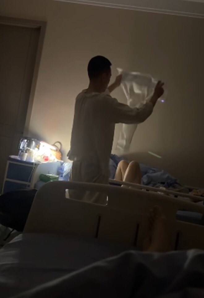 Nửa đêm, người chồng đang cầm một chiếc bỉm để chuẩn bị thay cho vợ.