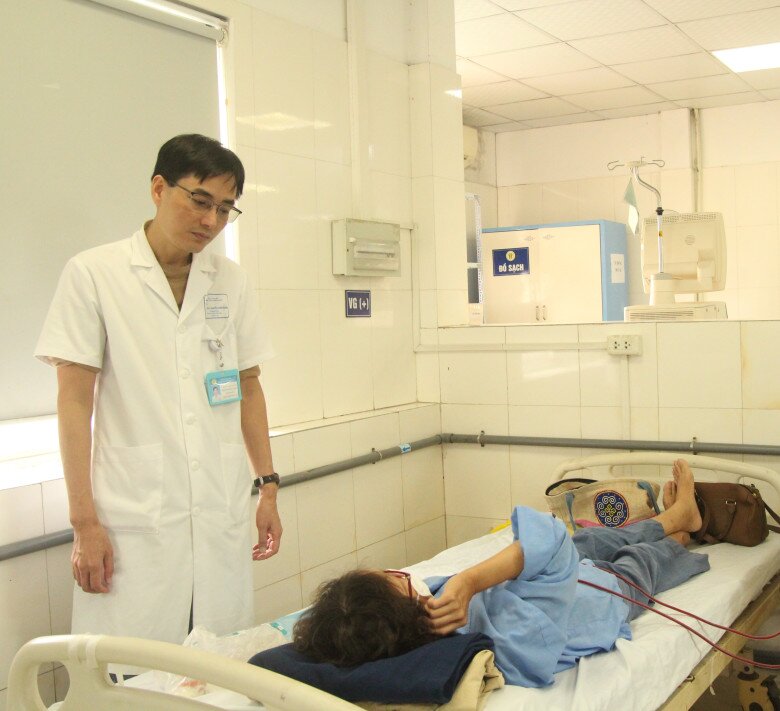 Bác sĩ Nguyễn Đăng Quốc đang thăm khám cho nữ bệnh nhân trẻ bị suy thận. Ảnh: Lê Phương.