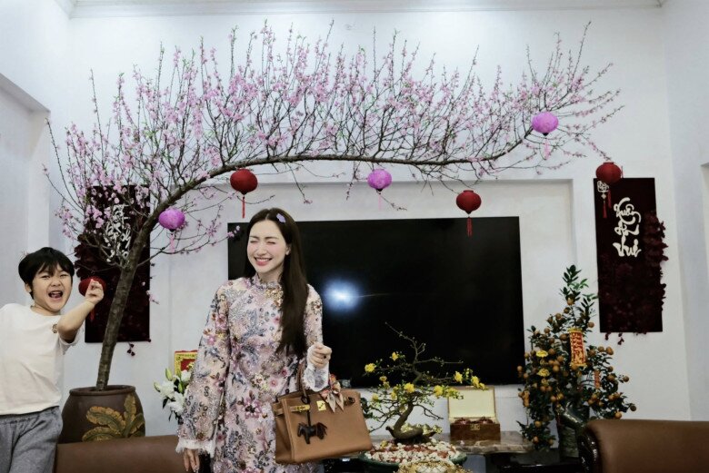 Hòa Minzy tươi tắn trong tà áo dài hoa, khoe khéo góc phòng khách sang trọng được bài trí nhiều cây cảnh đón xuân.