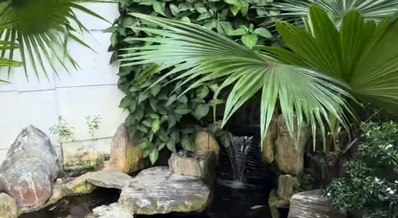 Góc thư giãn yên ả. Xung quanh mặt nước là những thảm cỏ xanh mướt và hòn non bộ được sắp đặt tỉ mỉ, giúp điều hòa không khí luôn mát mẻ và dễ chịu.