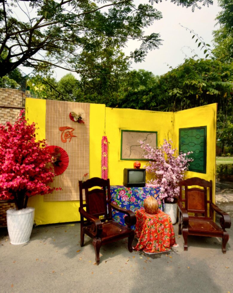 Điểm nhấn nội thất cổ điển với bình hoa trắng sứ đựng đào đông rực rỡ, hài hòa giữa sắc vàng của tường nhà và những phụ kiện trang trí mang đậm phong vị Tết.