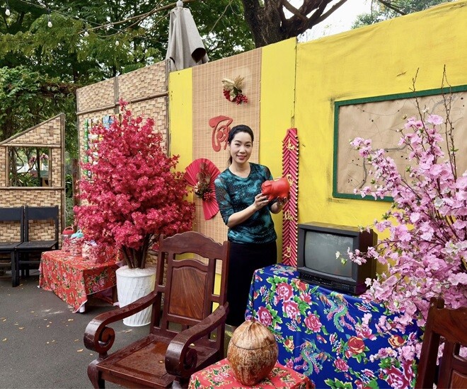 Góc tái hiện phòng khách xưa với tivi đen trắng đời cũ, bộ trường kỷ gỗ quý và những nhành đào hồng thắm lung linh cạnh cửa sổ xanh đặc trưng của nhà cổ.