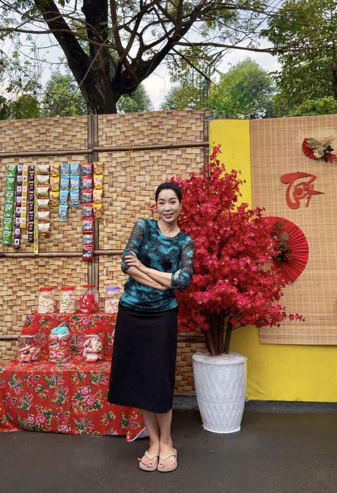 Bức tường rào đan tre tỉ mỉ trở thành phông nền hoàn hảo cho gian hàng bánh kẹo xưa, bên cạnh là chậu hoa được tạo hình công phu và rực rỡ sắc đỏ.