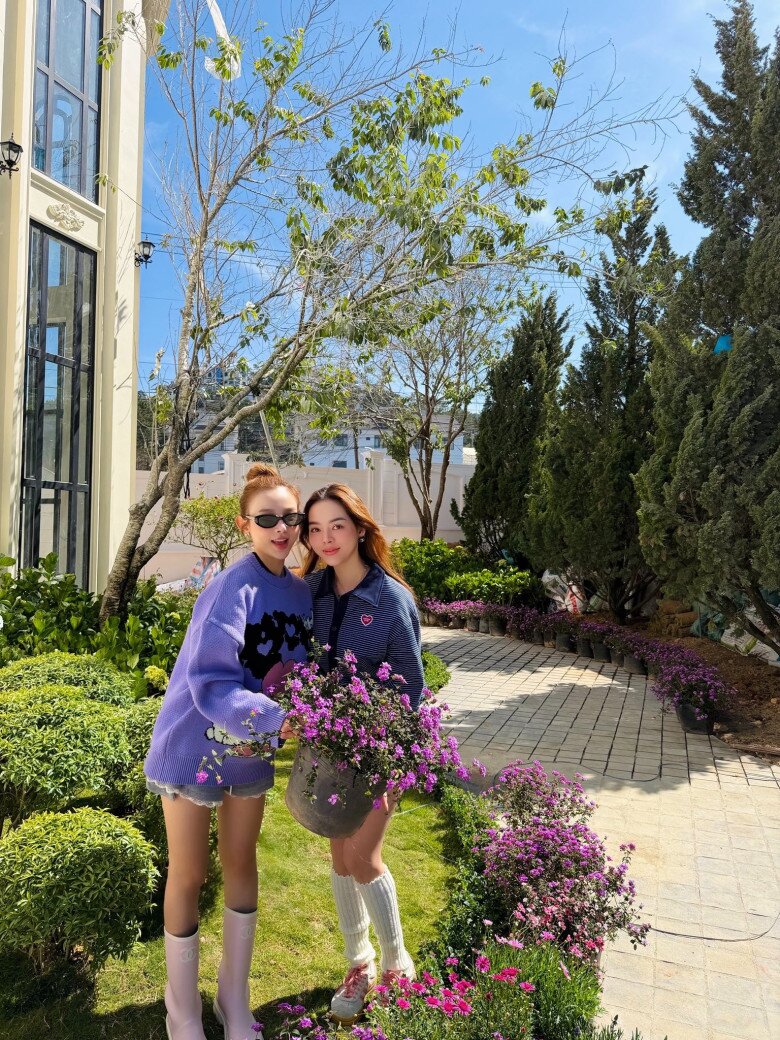 Ngay sát hiên nhà, lối đi lát đá cuội uốn lượn mềm mại dẫn lối qua những bụi hoa cẩm tú cầu trắng muốt và những tán cây lá kim đặc trưng của vùng đất cao nguyên, tạo nên một tổng thể hài hòa và tràn đầy sức sống.