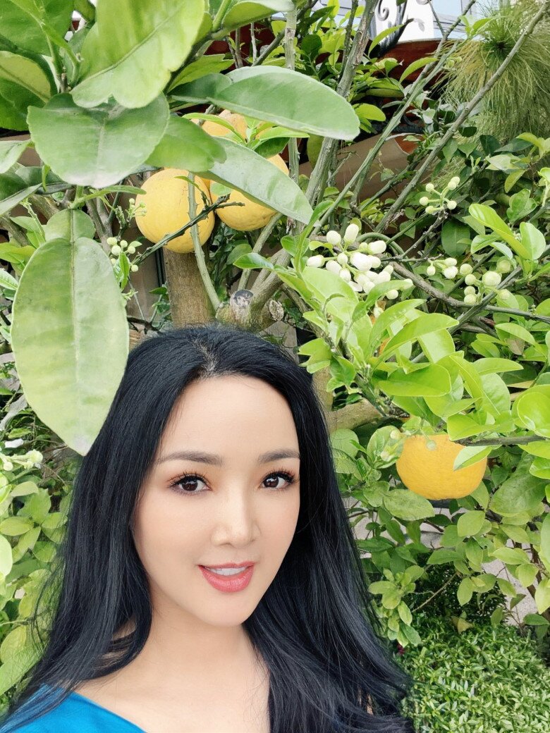 Giáng My rạng rỡ bên cây bưởi trĩu quả chín vàng và đầy lộc non, cô hào hứng khoe: Bưởi chưa thu hoạch đã trổ hoa thơm ngát.