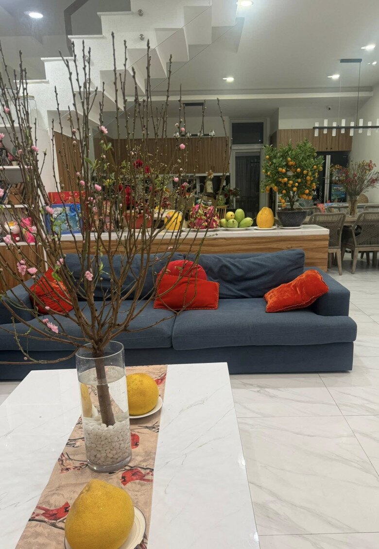 Bên trong nhà cũng được trang trí rất nhiều hoa lá. Một cành đào lớn được cắm trong bình gốm đặt tại phòng khách, mang nét đặc trưng của Tết miền Bắc vào không gian sống.