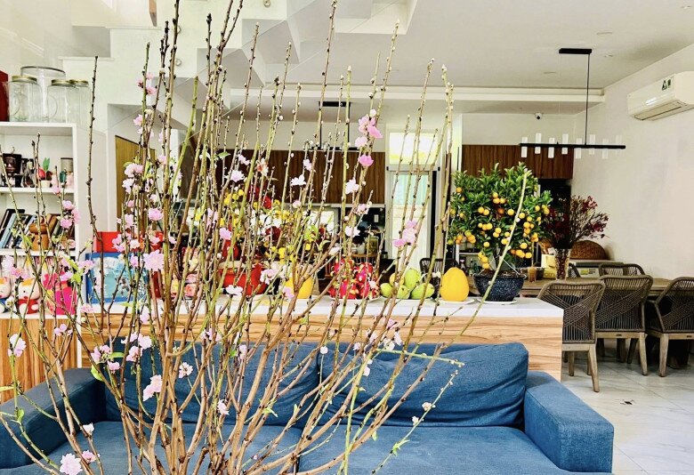 Sắc hồng của hoa đào hòa quyện cùng tông màu trầm ấm của nội thất gỗ, mang lại sự cân bằng cho tổng thể căn phòng.