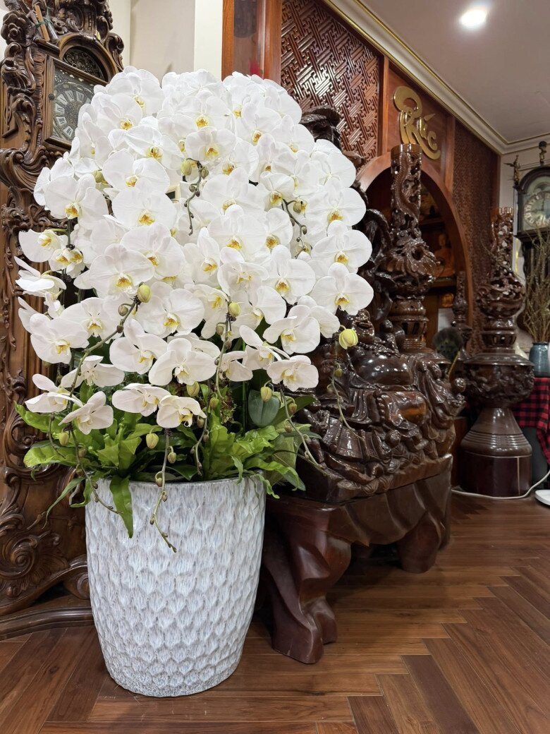 Sự phối hợp nhịp nhàng giữa những chậu hoa tươi mới, ánh đèn ấm áp và không gian nội thất gỗ mang đến một cảm giác hân hoan, rộn ràng của những ngày giáp Tết.