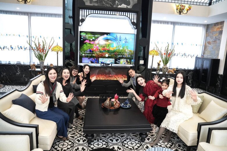 Nữ nghệ sĩ cùng chồng và bạn bè vui xuân mới. Phòng khách tràn ngập không khí hội ngộ, ngập đầy sắc xuân. Hệ thống cửa kính lớn thu trọn ánh sáng tự nhiên, làm nổi bật nền gạch bông họa tiết cổ điển.