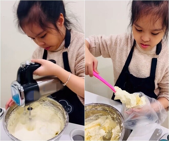 Khi kem đã đạt độ bông xốp hoàn hảo, nhóc tì cẩn thận múc kem cho vào túi bắt kem để chuẩn bị cho công đoạn trang trí hoàn thiện chiếc bánh.