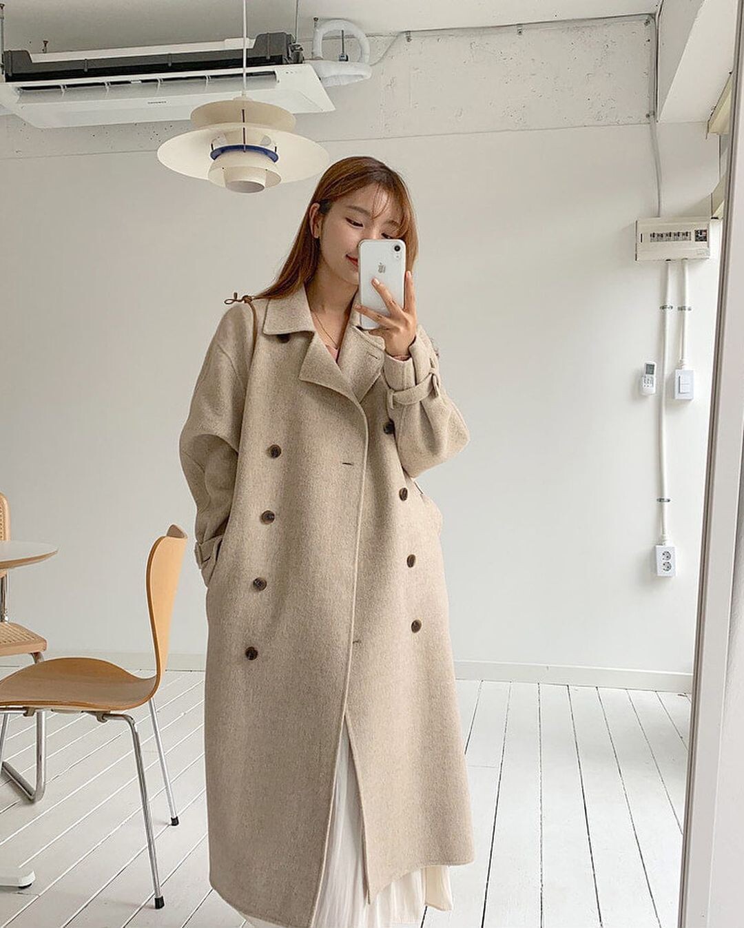 Trench coat mang phom dáng dài giúp cơ thể trông cao và thon hơn. Thiết kế tối giản, màu be hoặc kem tạo vẻ ngoài thanh lịch, trẻ trung mà không cần cầu kỳ.