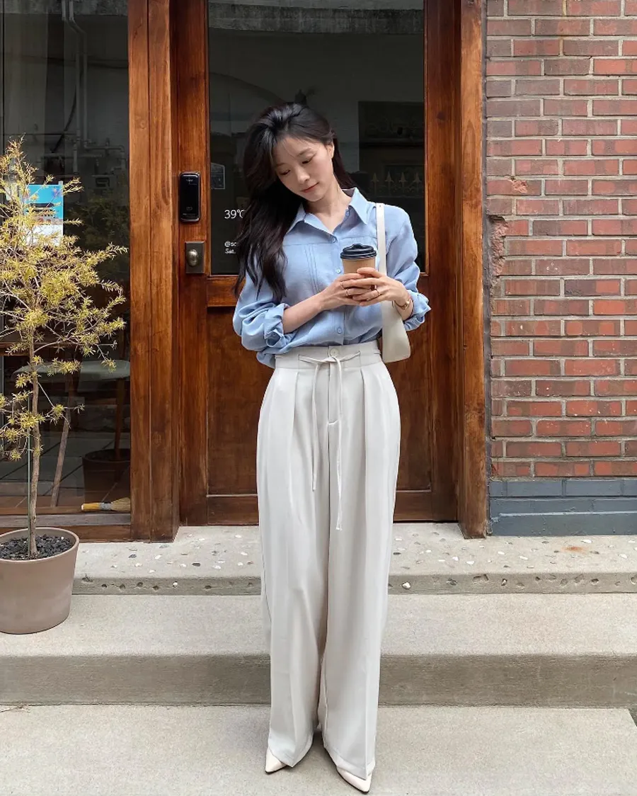 Áo sơ mi basic khi đi cùng quần trắng giúp tổng thể sáng sủa, tinh tế. Chọn form rộng vừa phải, chất liệu đẹp để tránh đơn điệu, đồng thời giúp outfit trông hiện đại và dễ ứng dụng.