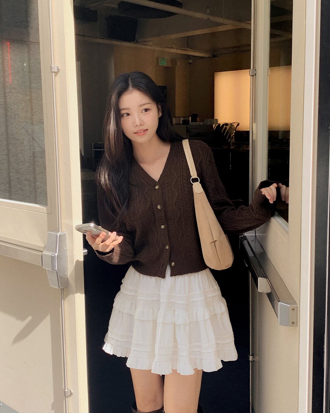 Áo cardigan mang lại cảm giác gần gũi, trẻ trung cho trang phục Tết. Khi phối cùng chân váy ngắn, outfit trở nên năng động và tươi mới hơn rõ rệt. Chỉ cần chọn độ dài váy vừa phải, công thức này vẫn giữ được sự tinh tế cần thiết.