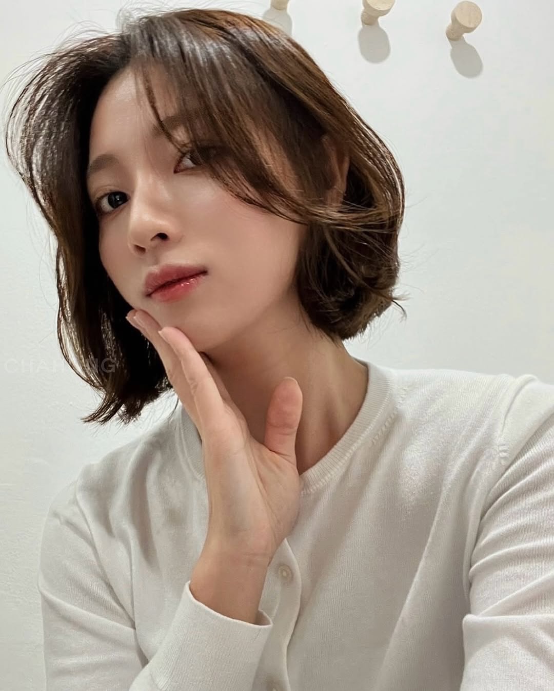 Tóc bob ngang cằm hoặc chạm vai, uốn cụp nhẹ và rẽ ngôi lệch giúp gương mặt tròn trông gọn gàng hơn, mang lại vẻ thanh lịch, hiện đại, dễ phối đồ ngày Tết.