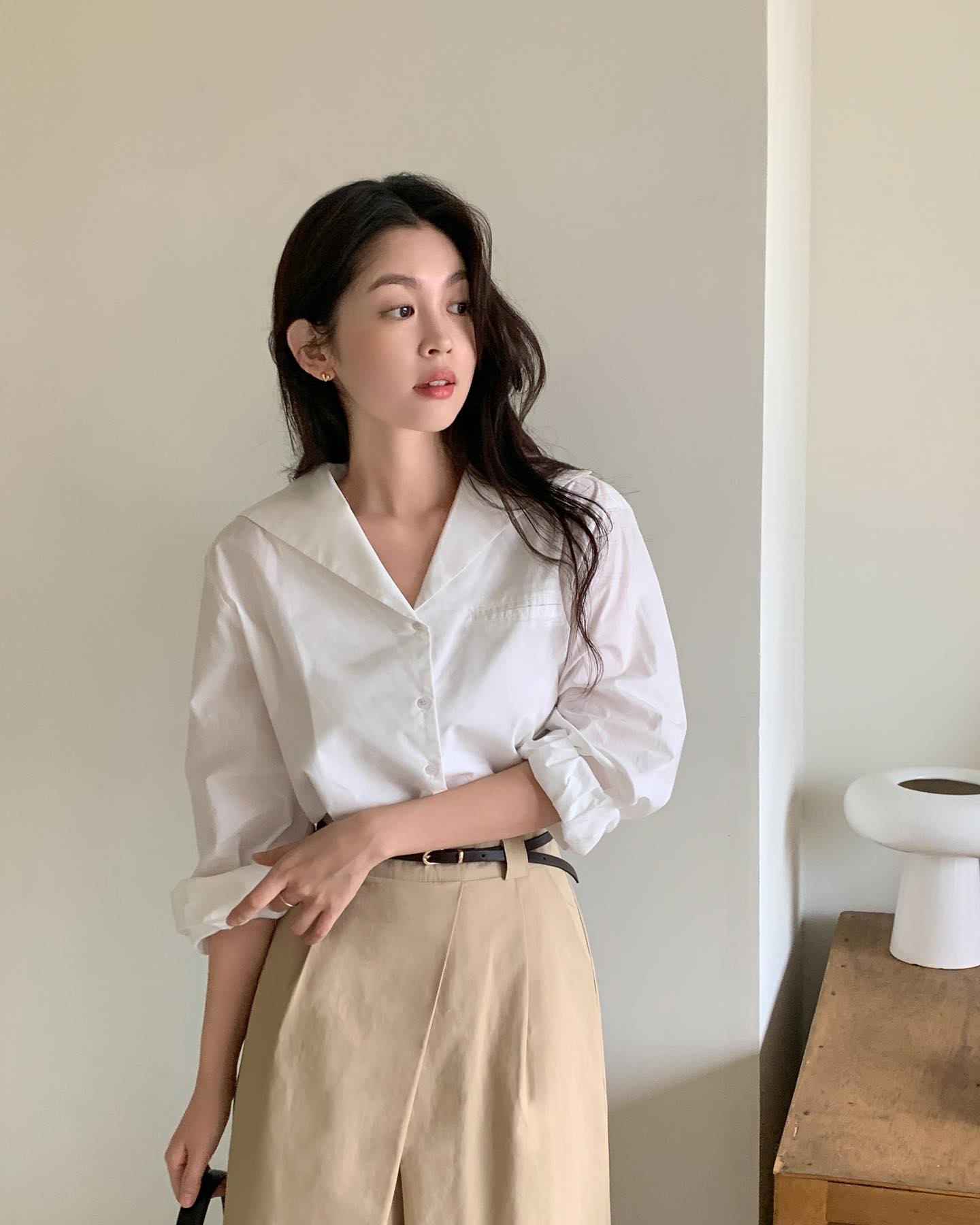 Áo sơ mi trắng là biểu tượng thanh lịch vượt thời gian, phù hợp từ công sở đến dạo phố. Phom suông nhẹ hoặc oversized vừa phải giúp tổng thể hiện đại hơn. Chất liệu đứng form, không quá mỏng sẽ giữ vẻ chỉn chu và dễ phối cùng quần âu, jeans hay chân váy.