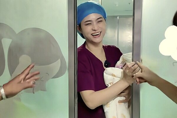 Bé sơ sinh vừa chào đời được bác sĩ bế ra ngoài gặp gia đình, đứa trẻ liên tục lấy tay che mặt - 1