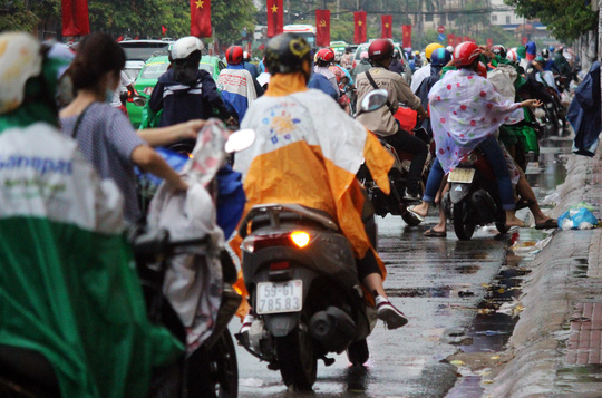 Trẻ nhỏ mệt mỏi cùng bố mẹ vượt mưa trở về thành phố sau kỳ nghỉ dài - 1