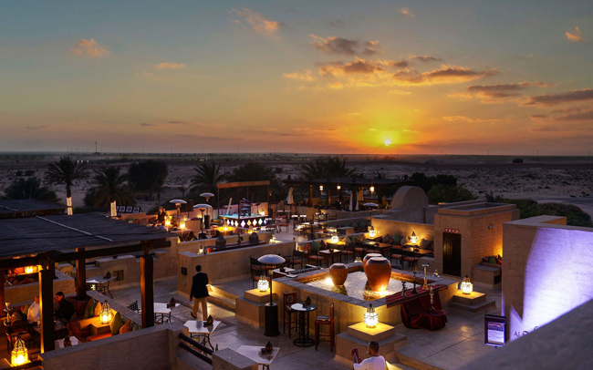 Nằm ở trung tâm của sa mạc và náu mình giữa những cồn cát của Dubai, quán bar trên mái nhà này như tắm mình trong ánh sáng với khung cảnh tuyệt đẹp của hoàng hôn.
