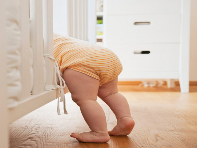 Đặt bé nằm sấp, khép hai chân và tìm dấu hiệu dị tật trật khớp háng nguy hiểm