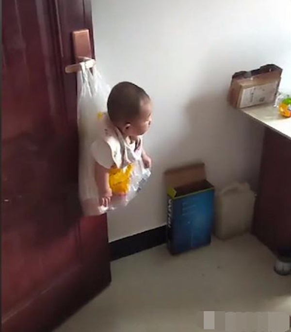 Bận chơi game, ông bố sáng tạo ra cách cho con vào túi nilon rồi treo lên cửa - 2