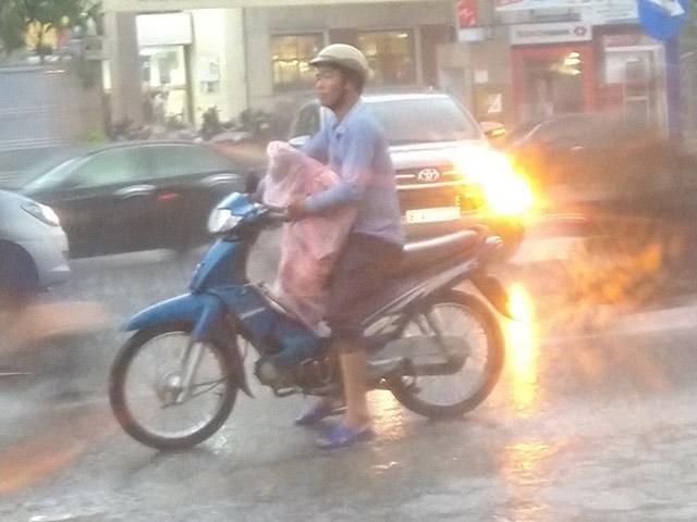 Xúc động hình ảnh người cha sẵn sàng chịu ướt để dành chiếc áo mưa duy nhất cho con