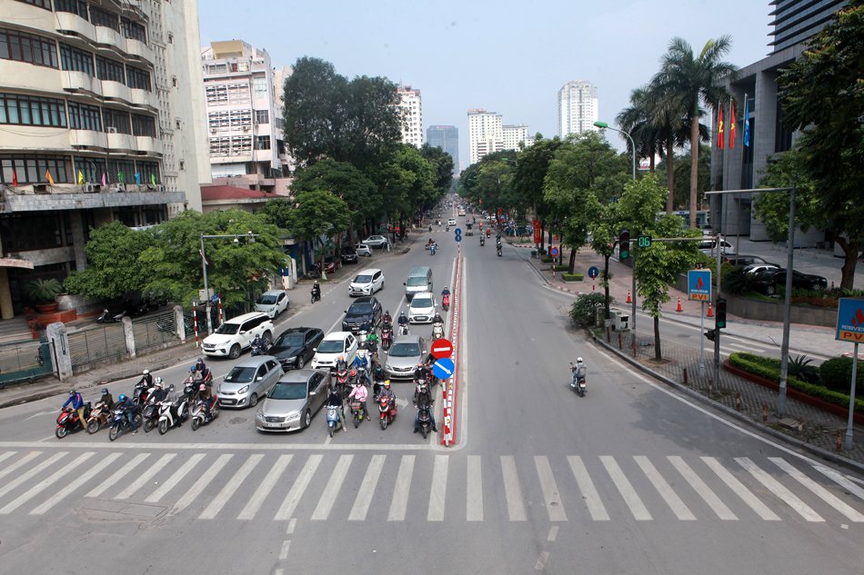 Người dân đứng chờ đèn đỏ trên phố Huỳnh Thúc Kháng