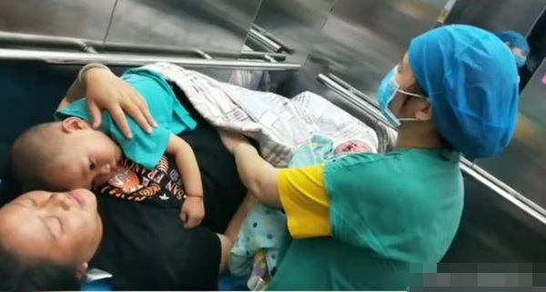 Xót xa hình ảnh bà đẻ chưa kịp ôm con bé đã phải vỗ về con lớn trên bụng - 1