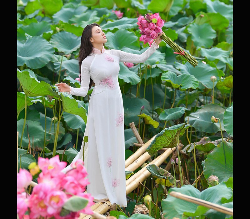 Giao Linh khoác lên mình tà áo dài trắng có hoạ tiết hoa đẹp mắt và ngọt ngào, với mái tóc dài suôn mượt đậm chất nữ tính như một nàng thơ chính hiệu.
