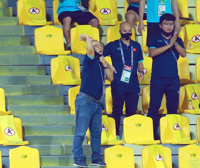 Thầy Park dùng tay ra ký hiệu chỉ đạo các học trò ở dưới sân