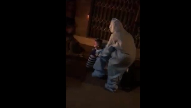 Người mẹ phải chạy lại giúp bé đội mũ và bế lên xe cấp cứu. (Ảnh cắt từ clip)