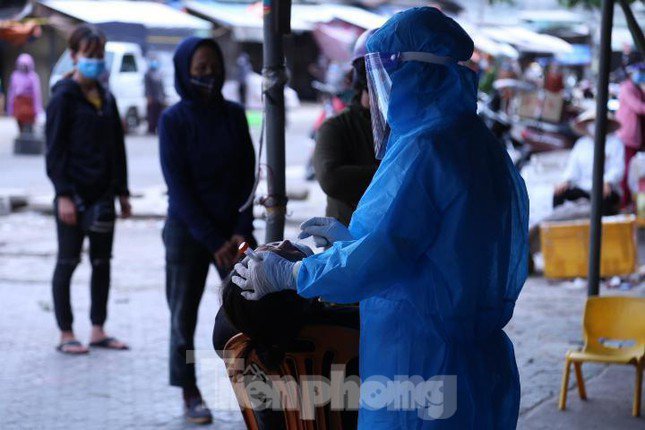 Lấy mẫu xét nghiệm cho các tiểu thương tại chợ đầu mối.