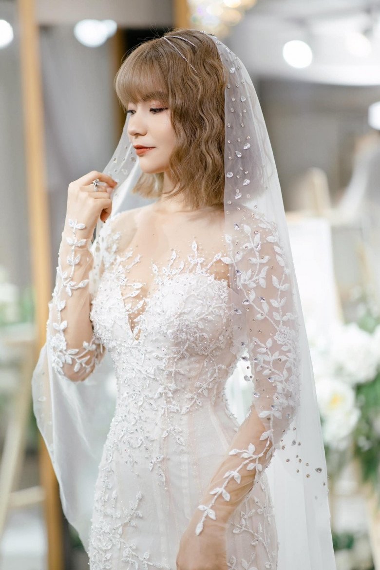 What bride is like Mac Van Khoa's wife, wearing a pristine wedding dress showing off her 