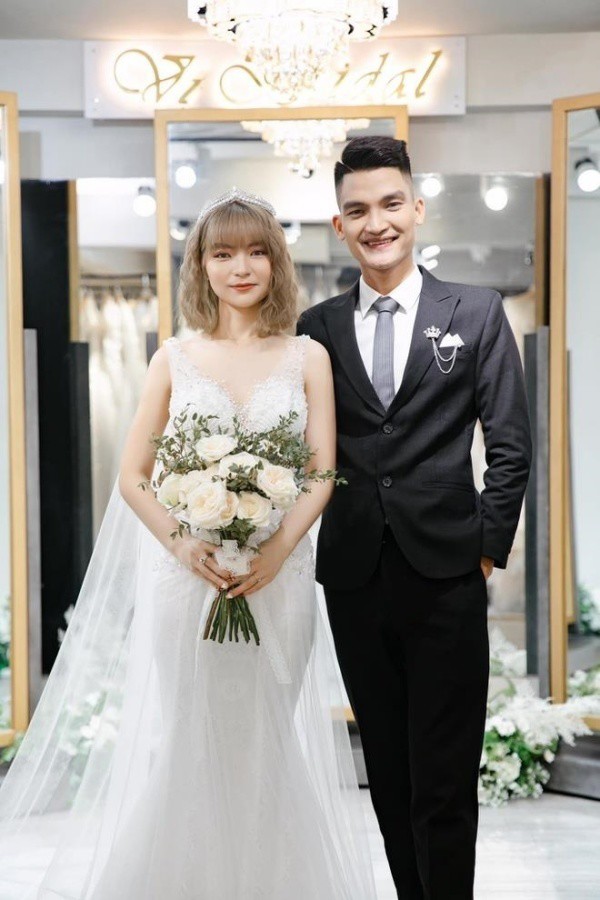 What bride is like Mac Van Khoa's wife, wearing a pristine wedding dress showing off her 