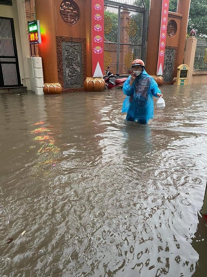 Khu vực Quan Nhân, phường Nhân Chính (Thanh Xuân, Hà Nội) đường ngập sâu xe máy không di chuyển được, shipper phải lội nước để giao hàng cho người dân.