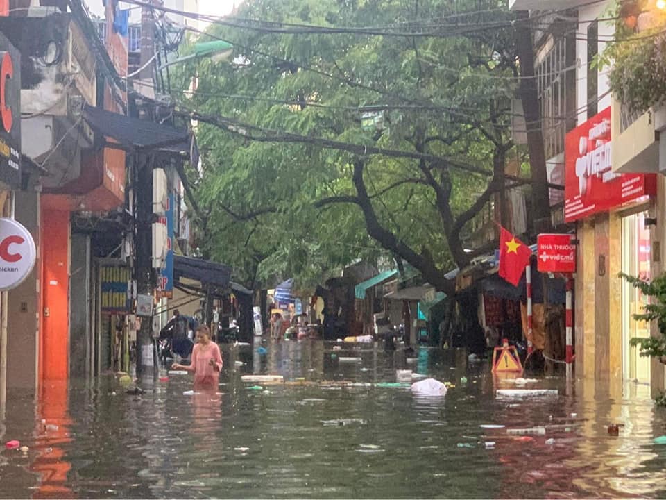 Phố Hoa Bằng (quận Cầu Giấy) ngập rất sâu. Nhiều rác nổi bồng bềnh trong dòng nước khiến việc đi lại, sinh hoạt của người dân gặp nhiều khó khăn.