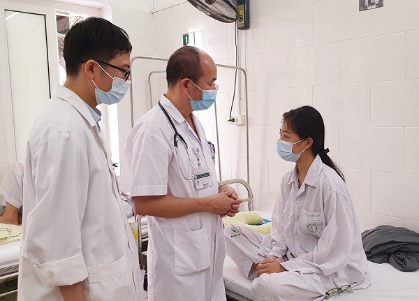 PGS.TS Đỗ Duy Cường - Giám đốc Trung tâm Bệnh nhiệt đới (áo trắng, ở giữa) thăm khám cho bệnh nhân đang điều trị tại Trung tâm.