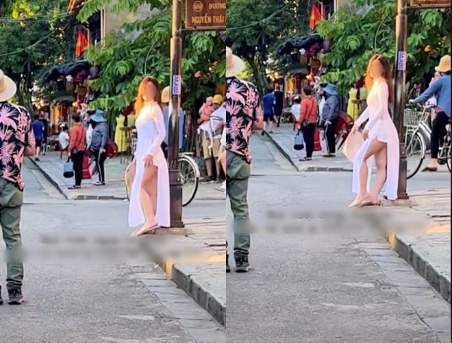 A female tourist wearing a thin long dress with shorts stands and flexes in the ancient town of Hoi An causing irritation - 1