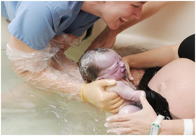 Khoảnh khắc em bé chào đời tuyệt diệu trong bồn nước và nụ cười tươi rói của nữ hộ sinh tạo ra khung cảnh ấm áp. 
