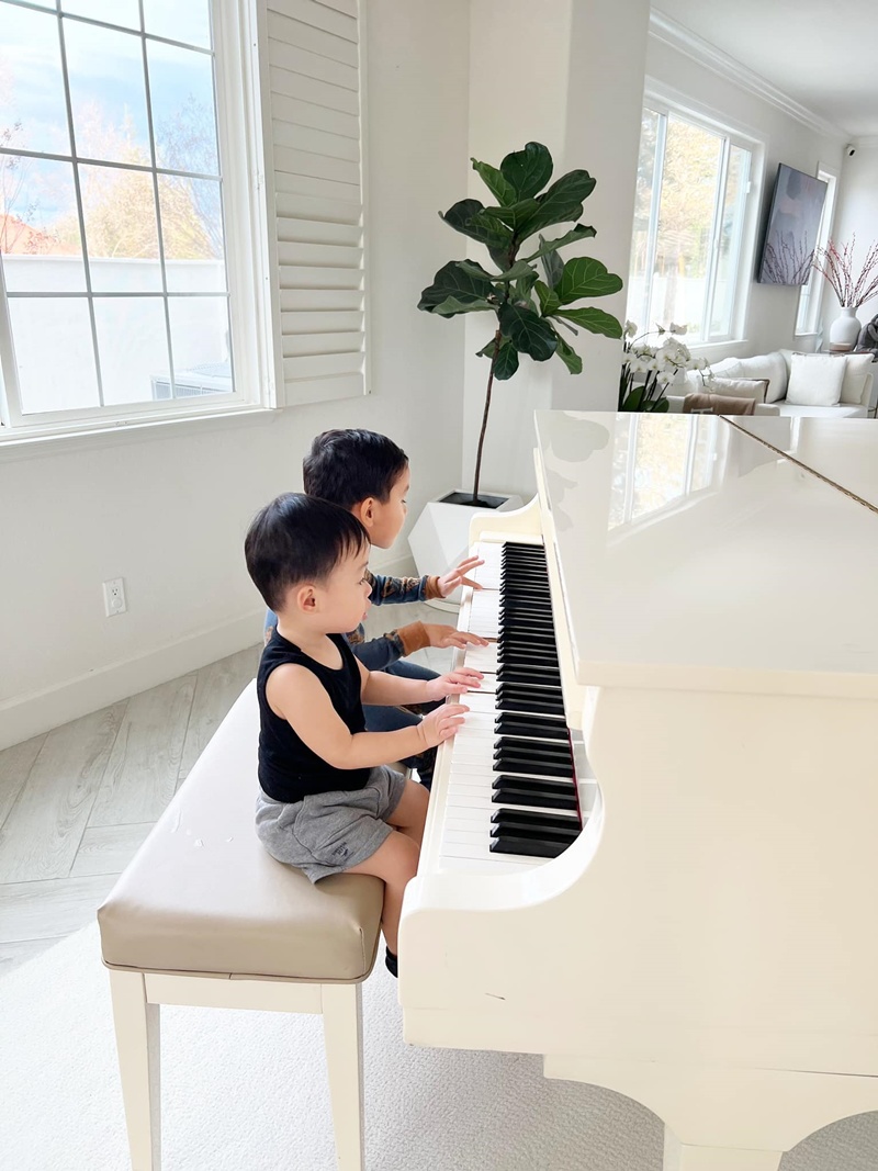 Phạm Hương còn đặt một chiếc đàn lớn trong phòng khách để 2 con chơi đàn tại nhà. 2 cậu bé thích thú ngồi trên ghế băng dài và say sưa tạo ra những giai điệu.

