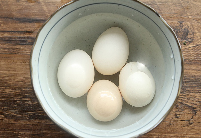 Rửa sạch trứng. Lúc này không cho trứng vào nồi trực tiếp mà trước đó hãy ngâm trứng trong nước 30 phút, nhất là trứng vừa lấy ra khỏi tủ lạnh. Nếu bạn luộc trứng trực tiếp thì chênh lệch nhiệt độ sẽ rất lớn, gây ra nứt vỏ. 
