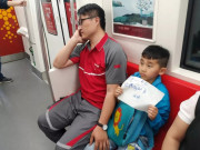 Làm mẹ - Cậu bé giơ cao 1 tờ giấy và liếc nhìn người đàn ông bên cạnh, đọc dòng chữ tất cả mọi người đều giật mình