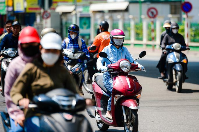 Trước ánh nắng gay gắt, người dân ra đường tham gia giao thông gần như bịt kín mít.