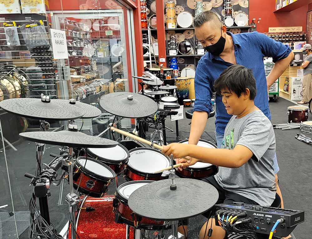 Hình ảnh Huy MC hướng dẫn con trai của Dũng Taylor và Thu Phương chơi trống.