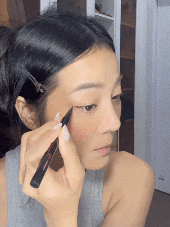 Karen thực hiện hết các bước đánh nhũ và kẹp, chuốt mascara mi và sau đó mới kẻ mắt. Đây là mẹo nhỏ rất hay cho những ai mới tập make-up vì bước kẹp mi nếu không khéo có thể làm lem nhem eyeliner. Người đẹp chỉ kẻ ở 1/3 đuôi mắt và tút tát ở góc mắt để cho mí mắt được to, rõ ràng.