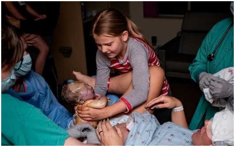 Đây là hình ảnh gia đình ngọt ngào và gắn kết bên nhau khi em bé được chính tay chị gái ôm đỡ lấy. 
