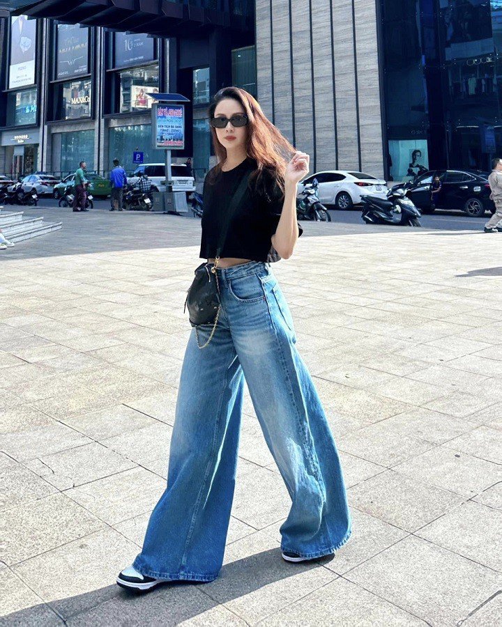 Hồng Diễm áp dụng công thức 1 ngắn - 1 dài cùng item quần jean ống rộng và áo croptop giúp hack dáng. Cô cũng tinh tế khi lựa chọn một chiếc quần jean ống rộng sáng màu để diện mạo trẻ trung hơn.