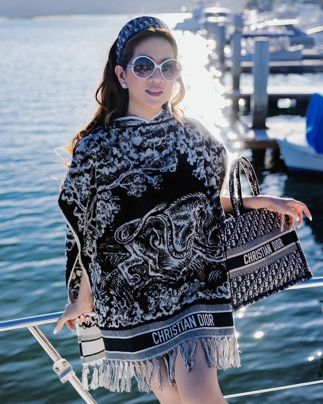 Mimi diện áo poncho và túi Book Tote của Dior.