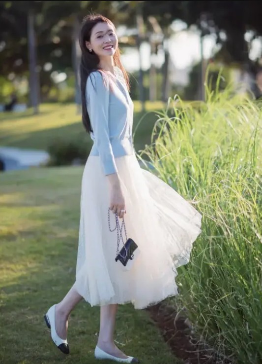 Chiếc sơ mi xanh được điểm nhẹ trên nền váy trắng sữa thể hiện sự tươi trẻ, tràn đầy sức sống.