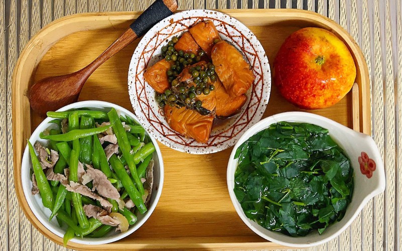 Mâm cơm cữ với các món: Cá hồi kho tiêu xanh, đậu cove xào, canh rau ngót rất tốt cho bà đẻ.
